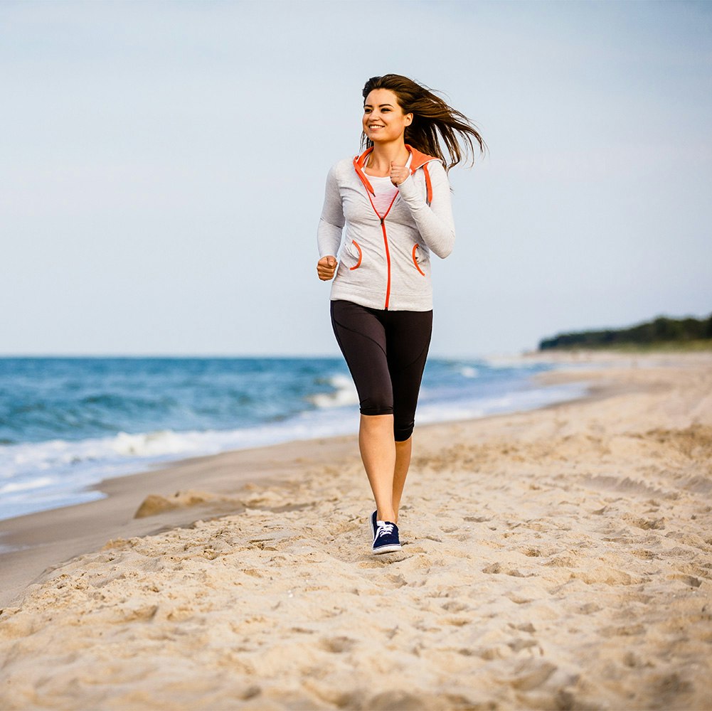 Woman after duodenal switch surgery power walking on a beach